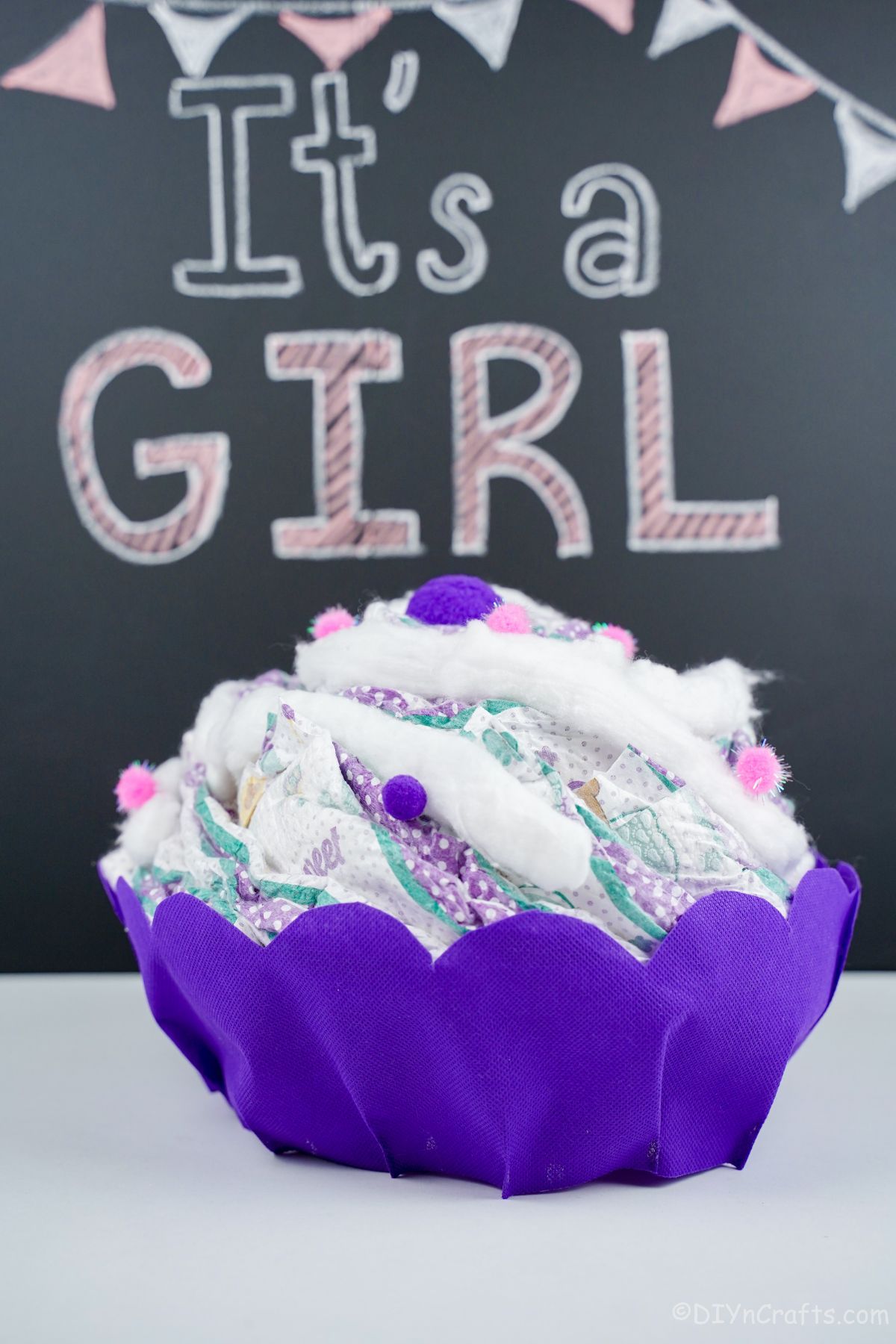 purple cupcake diaper on table with chalkboard sign in background