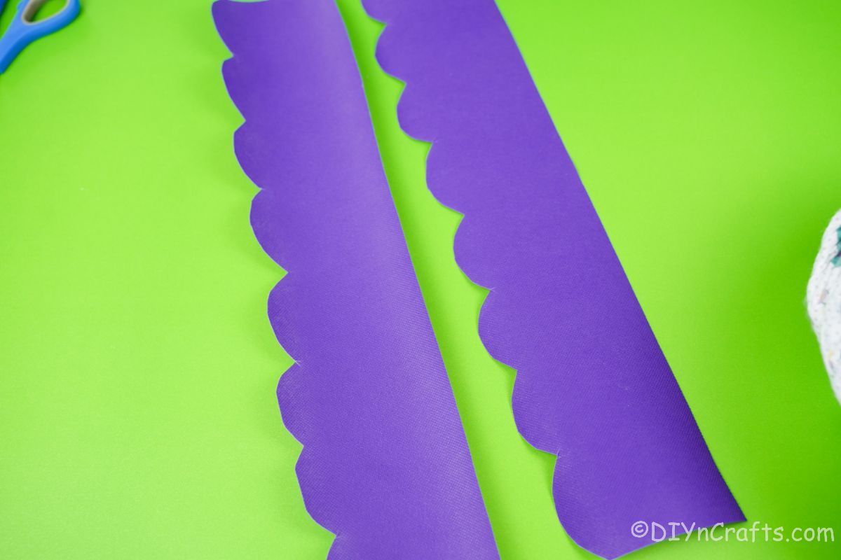 two lengths of purple tissue paper on green table