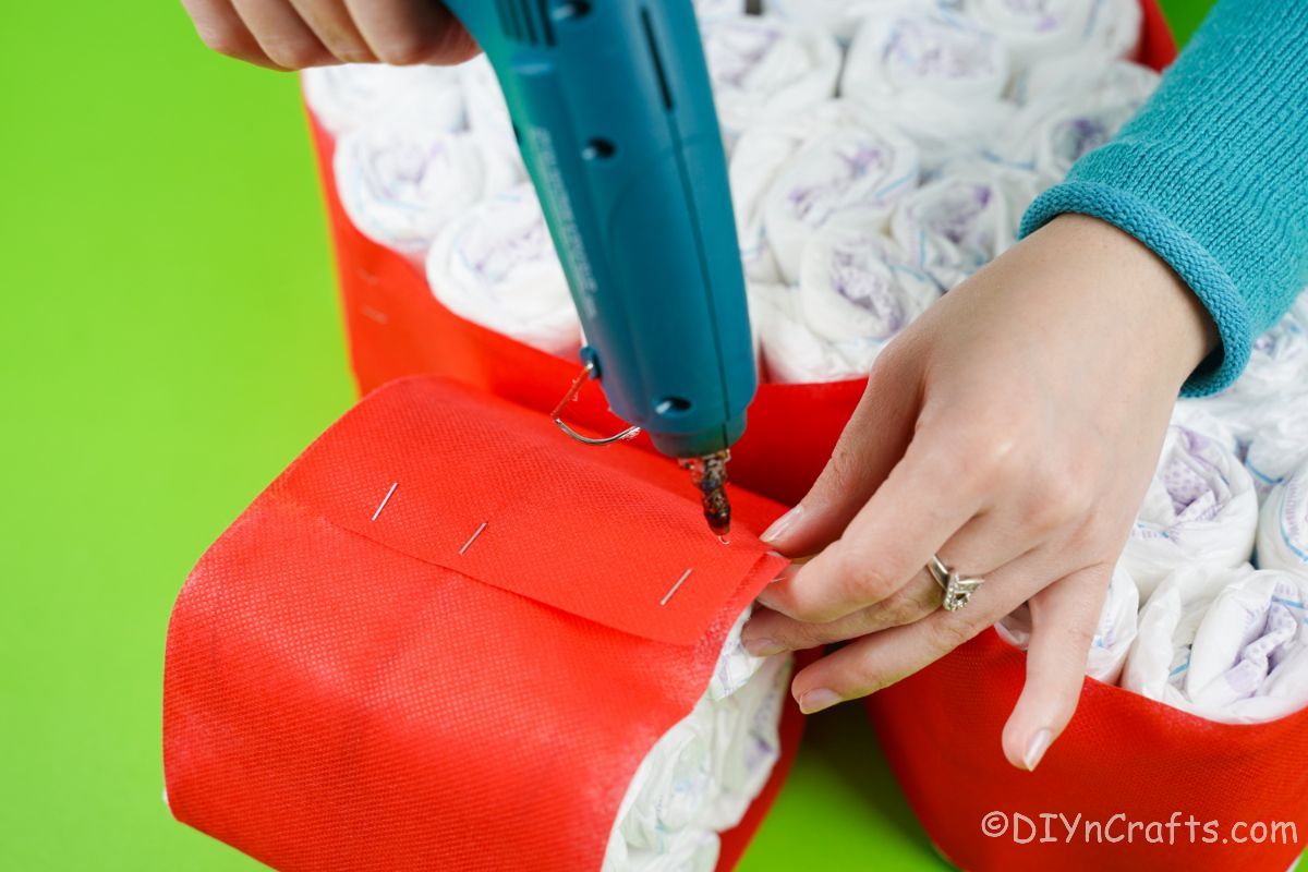 gluing bundles of diapers together with blue hot glue gun