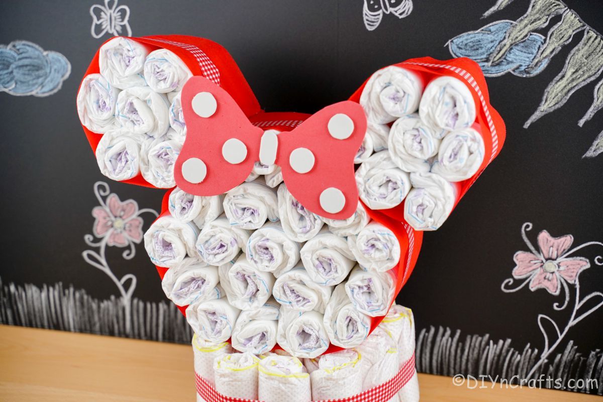 red and white Minnie Mouse diaper cake in front of chalkboard wall