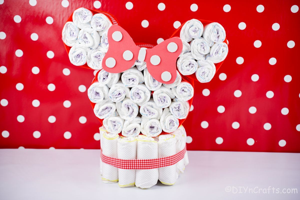 diaper cake Minnie Mouse head in front of red and white polka dot wall