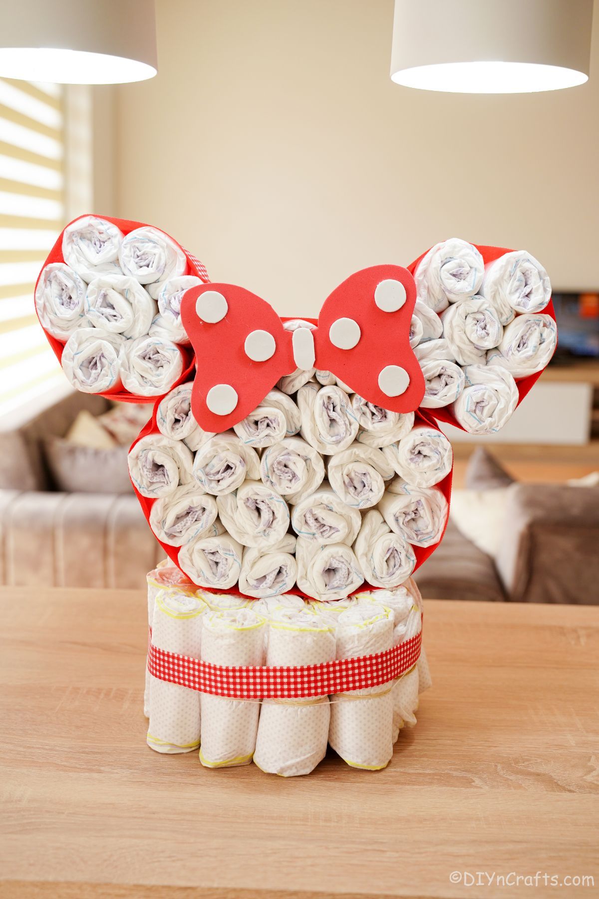 Minnie Mouse diaper cake on table with red and white ribbon