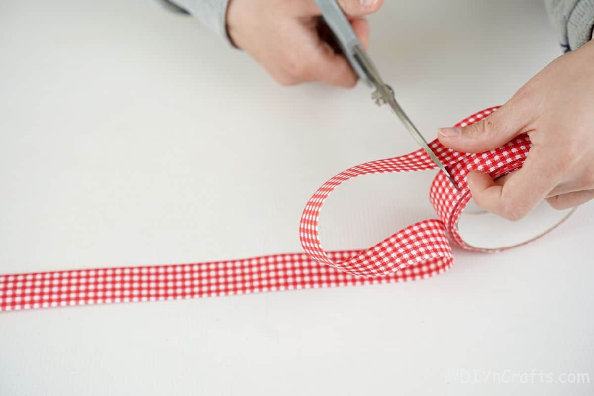 hand cutting red and white ribbon