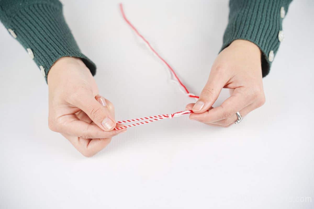 hand tying red and white yarn together