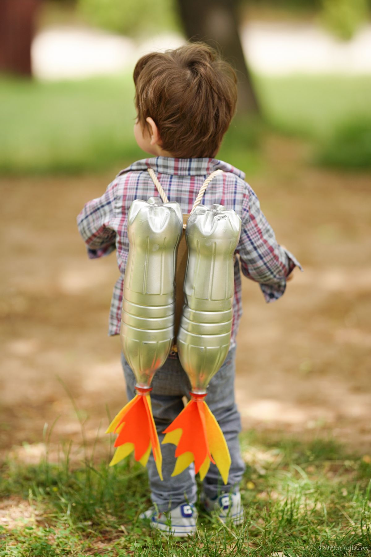 little boy wearing jet pack costume made of plastic bottles