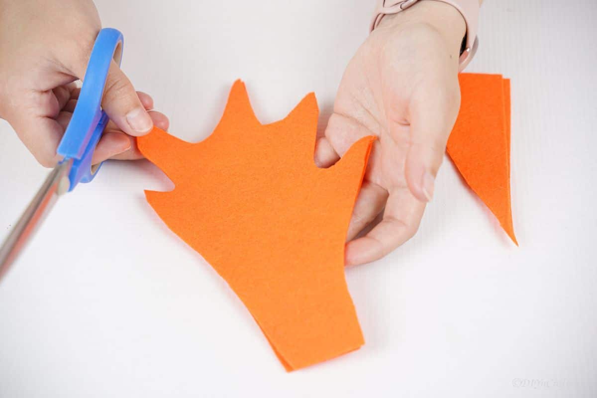 hands holding orange felt flame