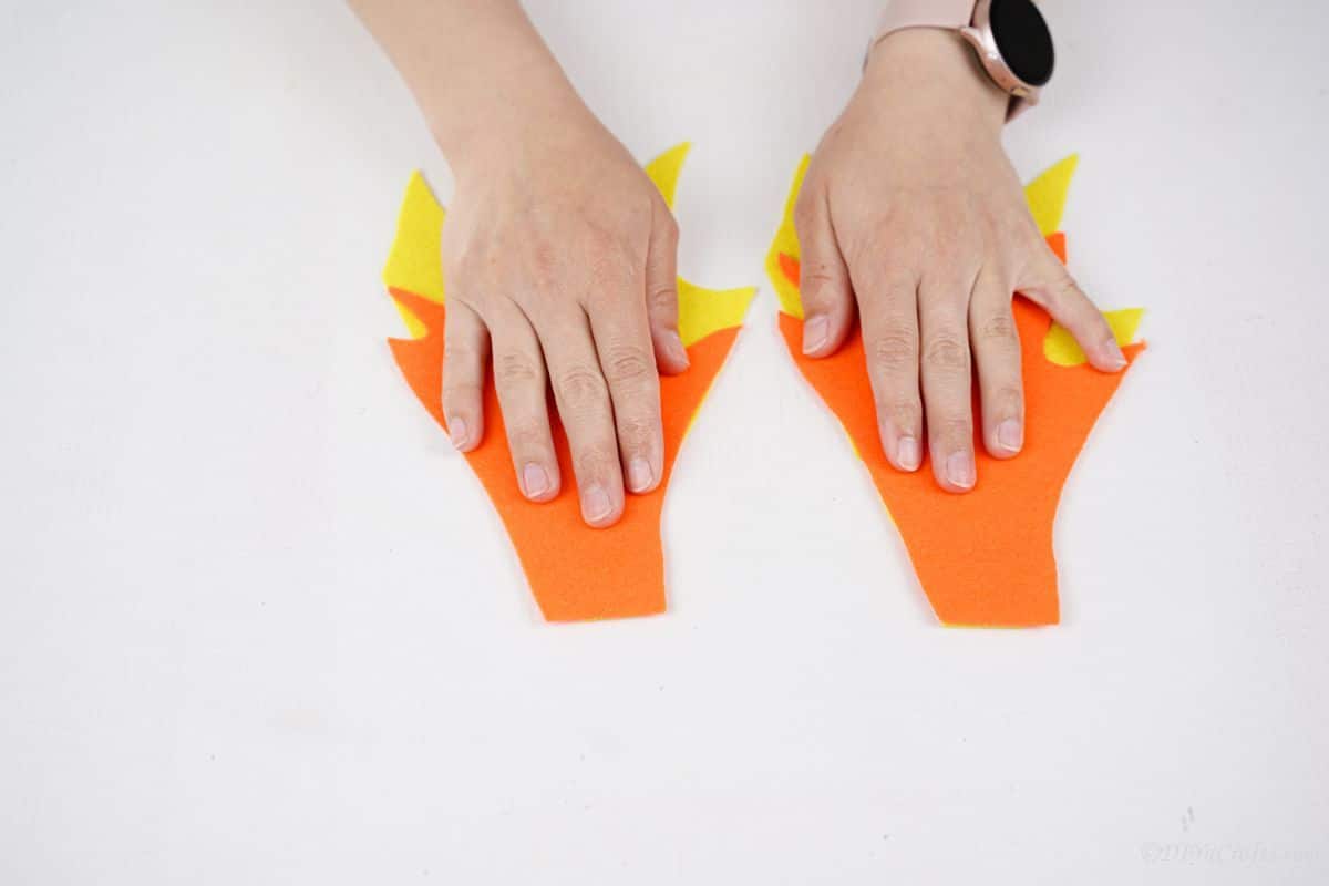 hand holding orange flame over yellow fabric flame