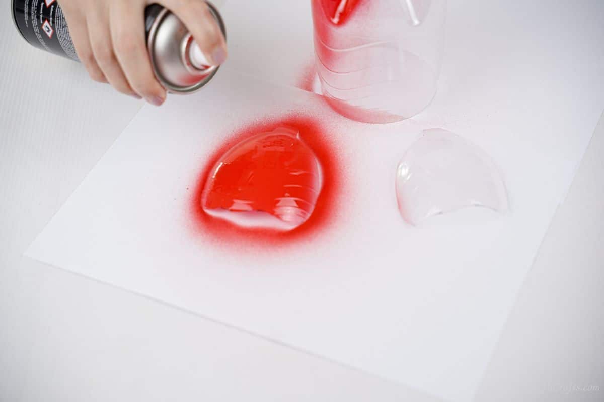 plastic wing pieces being sprayed with red paint