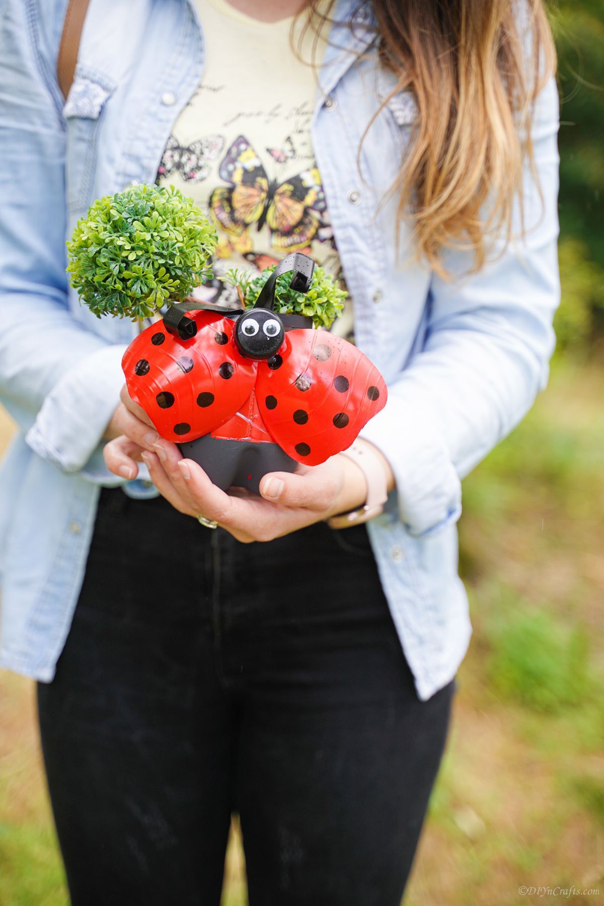 red ladybug planter held by woman