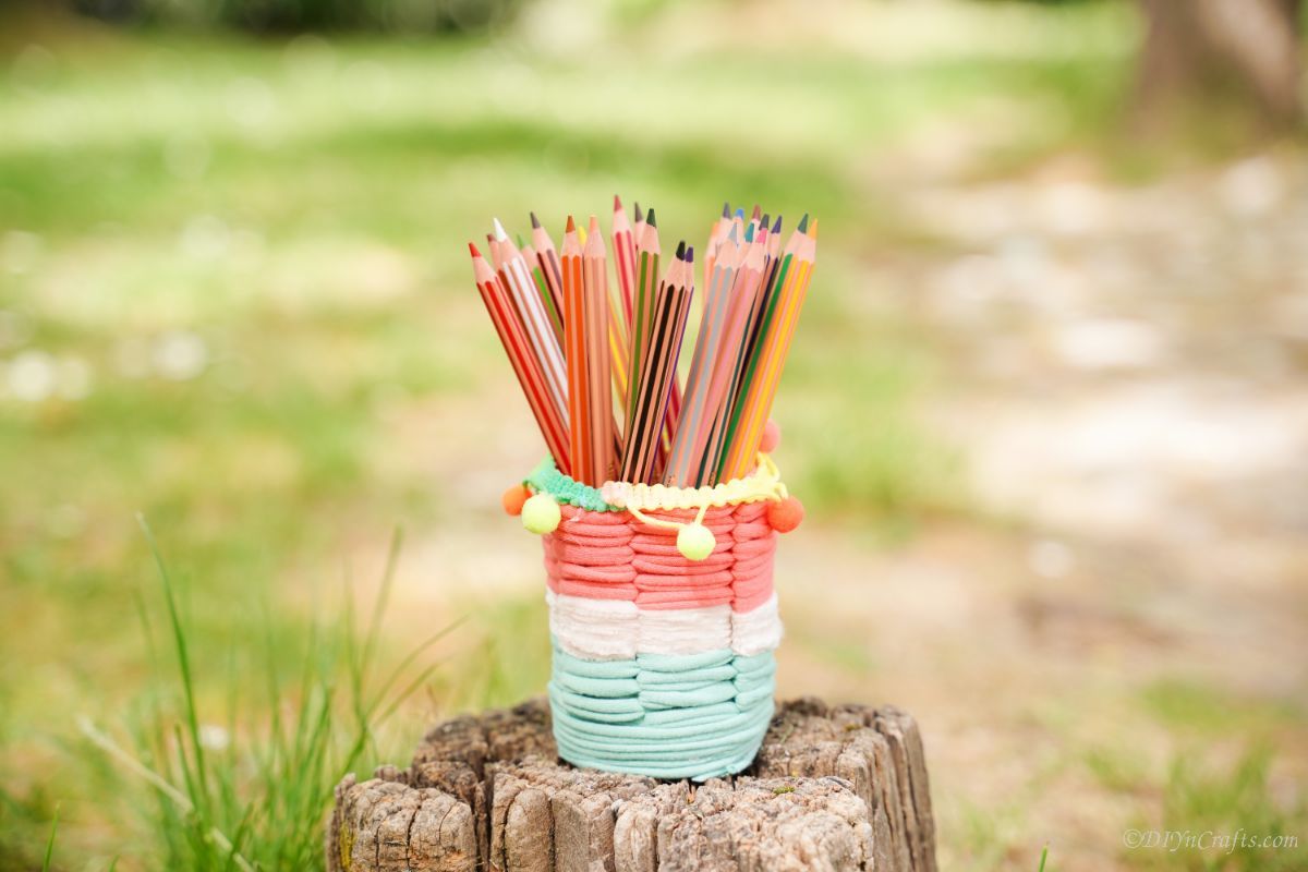 striped pencil cup sitting on stump