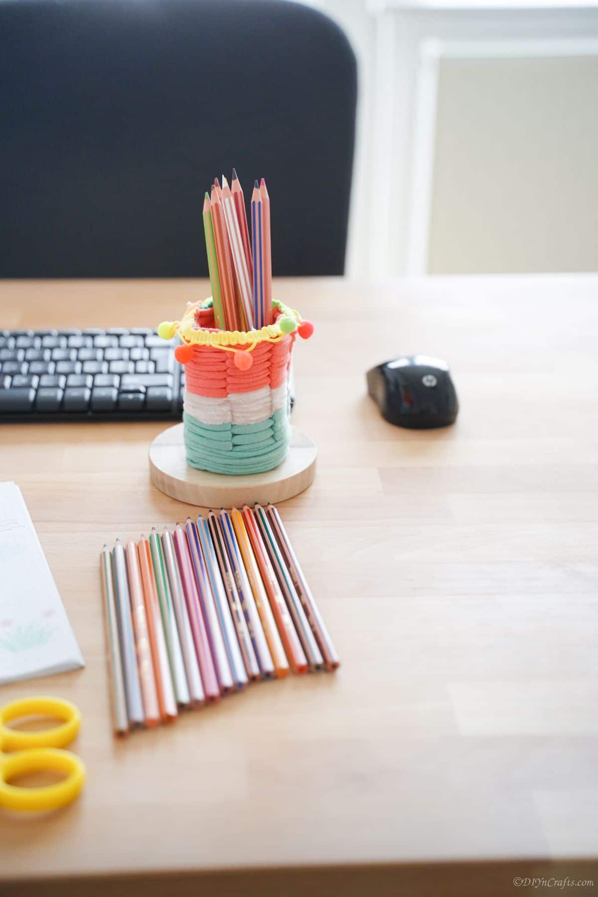 striped yarn pencil cup on desk by black keyboard and mouse