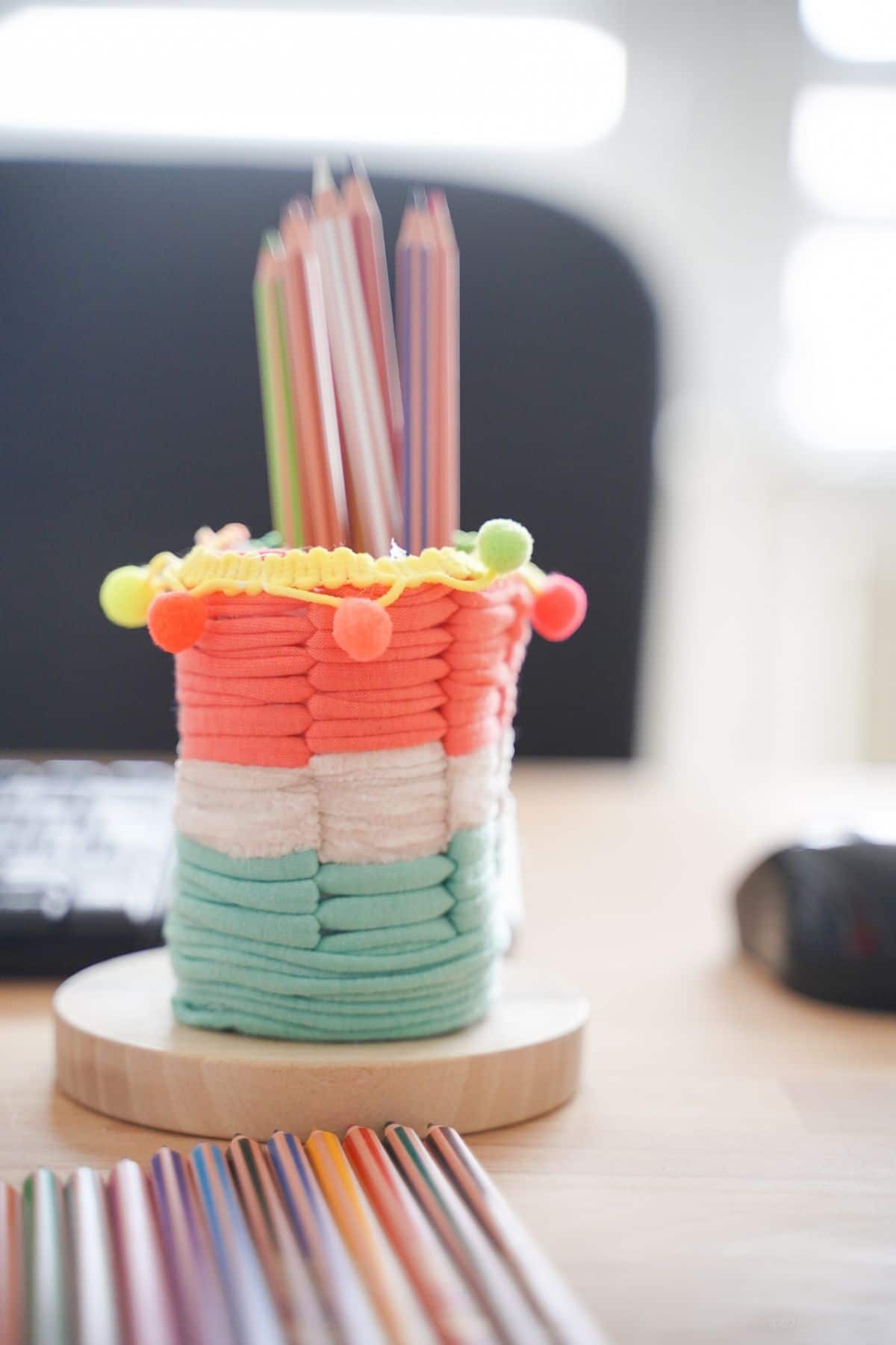 pink white and green yarn pencil cup on desk