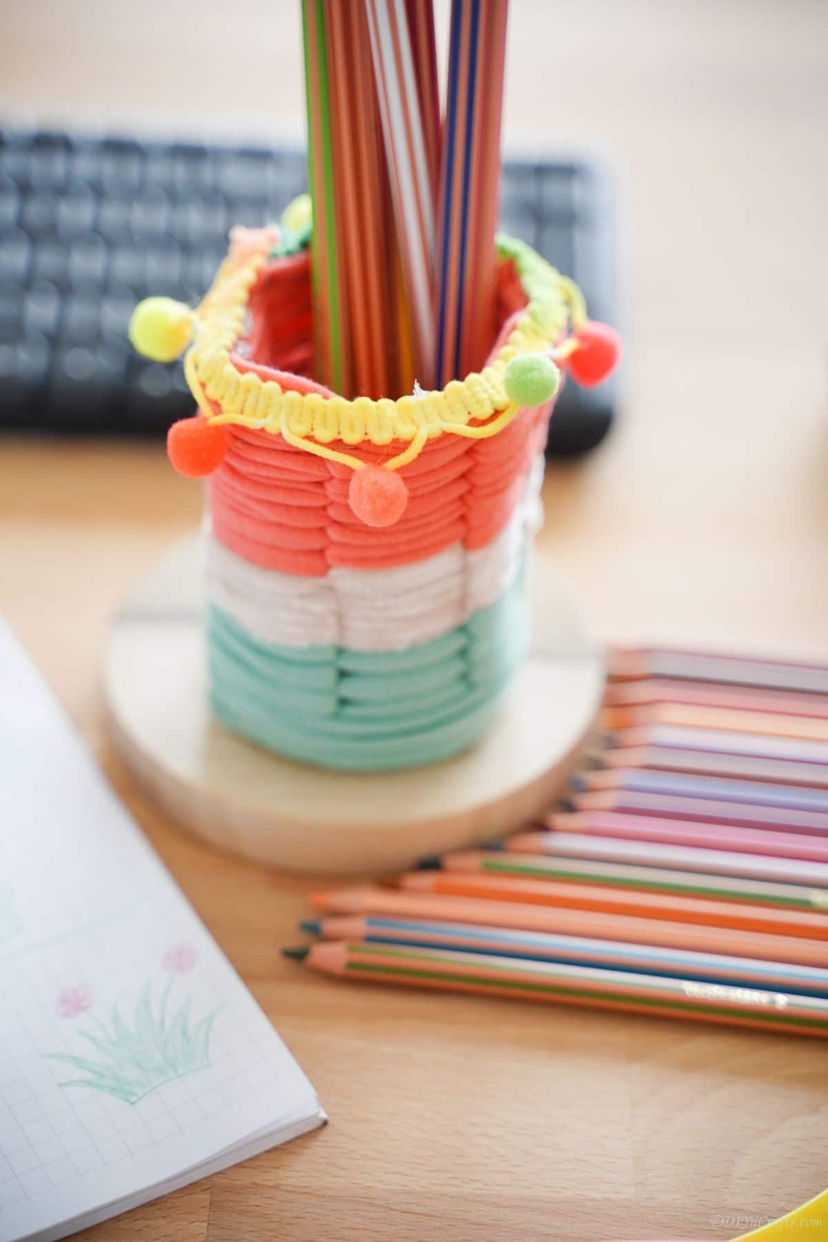 pencil holder on table next to colored pencils