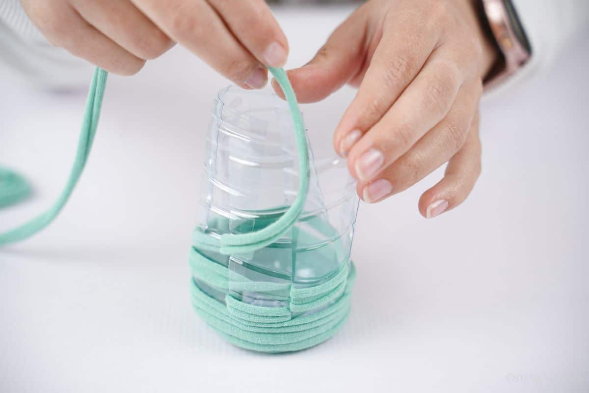 green yarn wrapping around plastic bottle