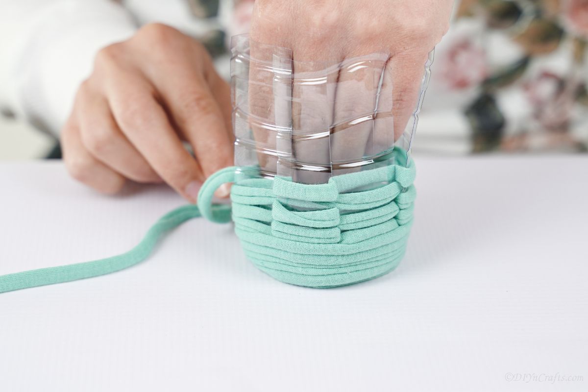 mint green cloth yarn being wrapped around plastic cup