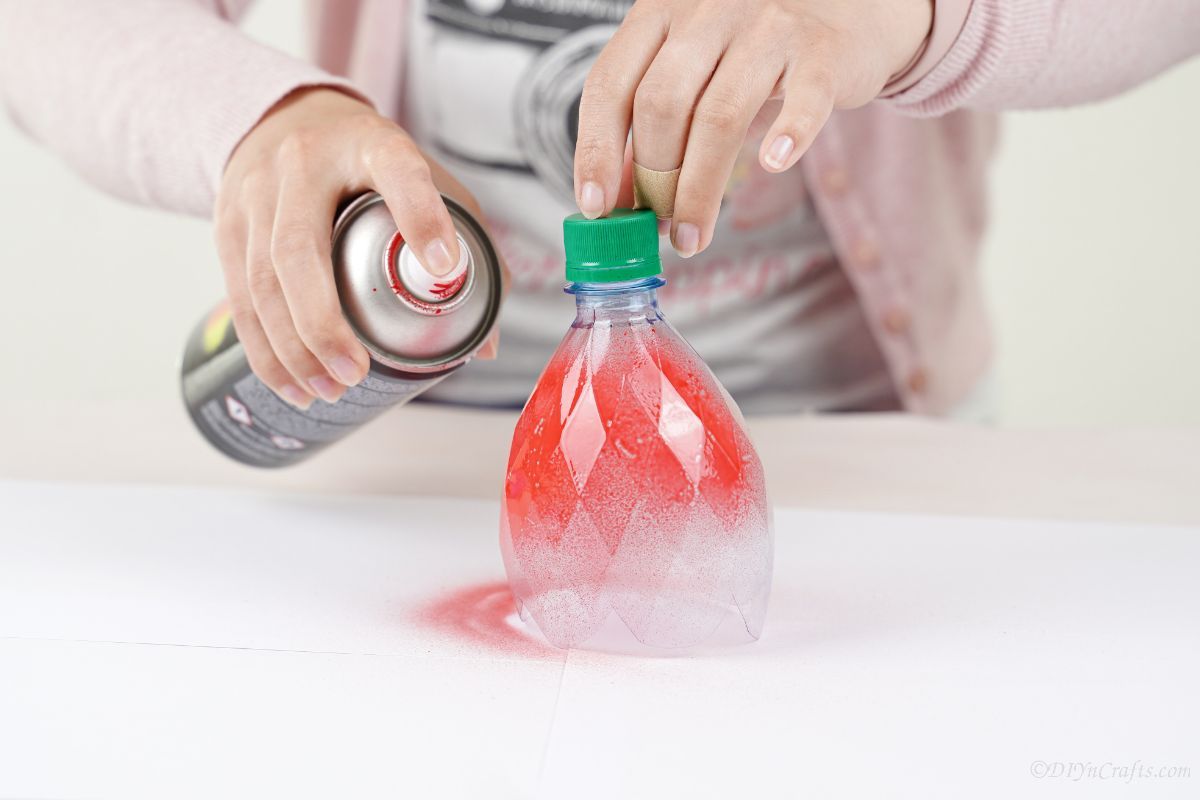 lady spray painting bottle red