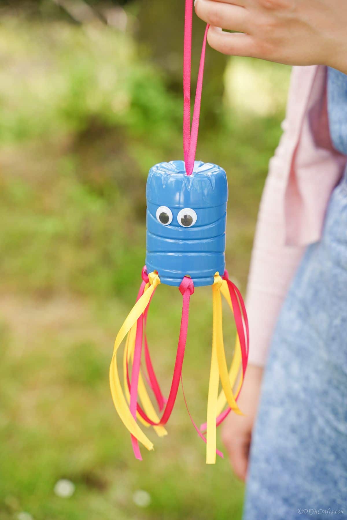 plastic bottle windsock hanging from woman hand