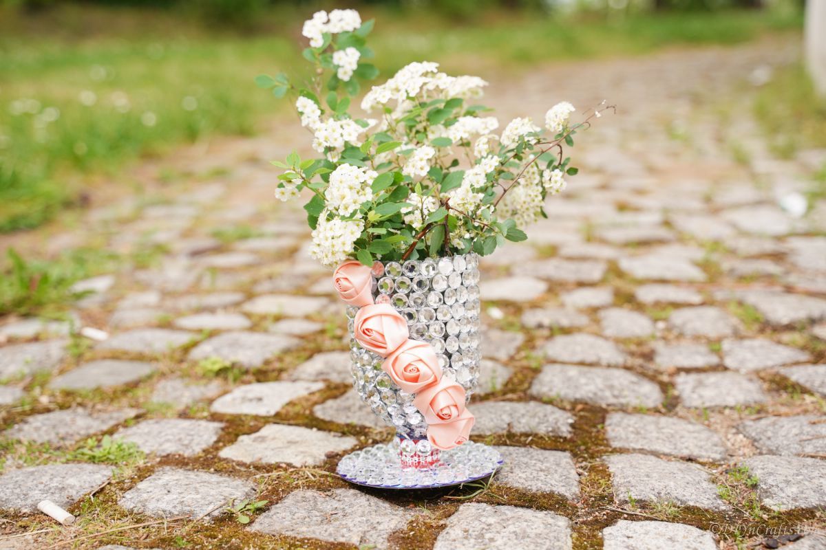 flowers in vase on cobblestone