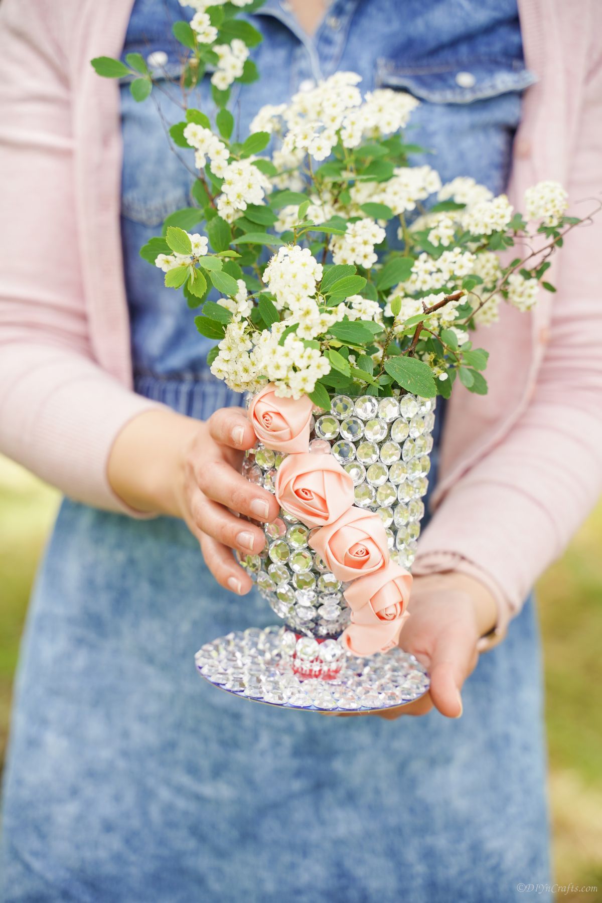 lady in denim jumper holding rhinestone covered vase