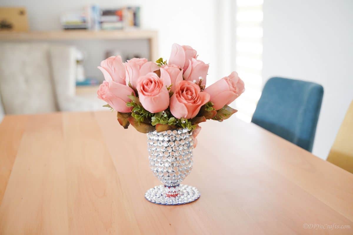 plastic bottle vase on dining table with blue chairs