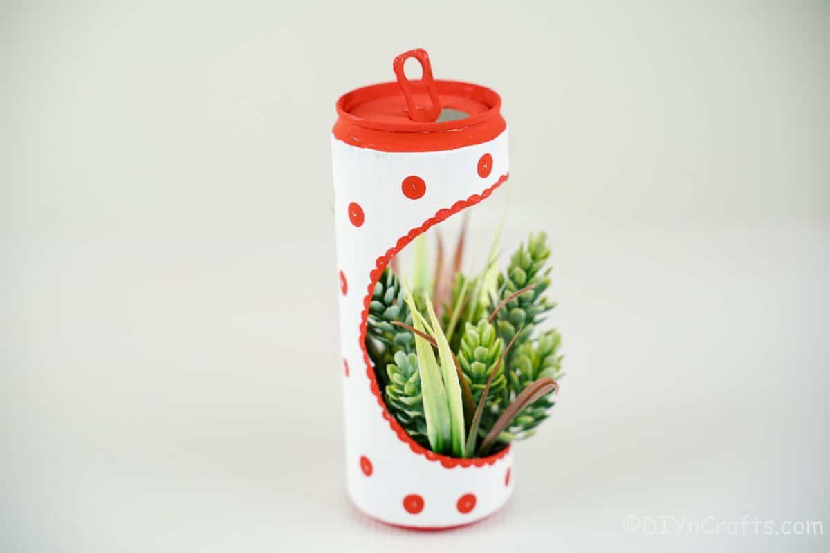 soft drink can turned into a planter with fake succulents