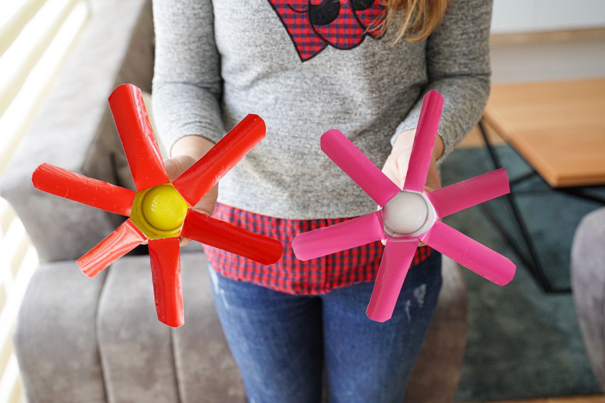 red and pink metal flowers held by woman in gray sweater