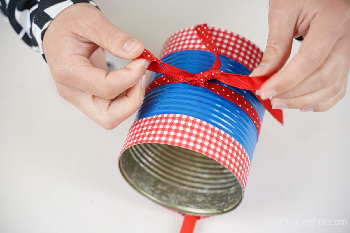 hand tied red polka dot bow around center of bird feeder can