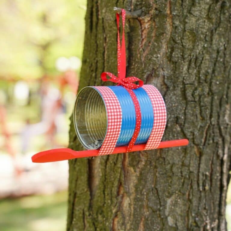 blue and red tin can bird feeder hanging on tree