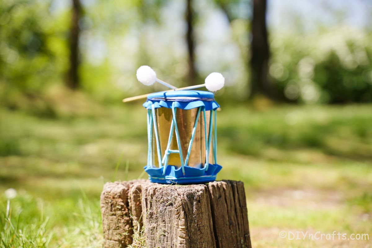 blue and gold tin can drum on stump