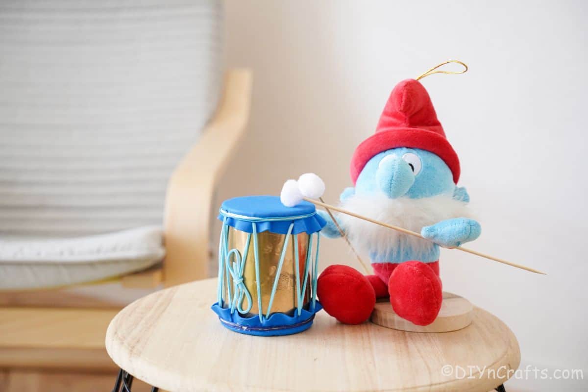 blue and gold mini drum on table with pap smurf toy