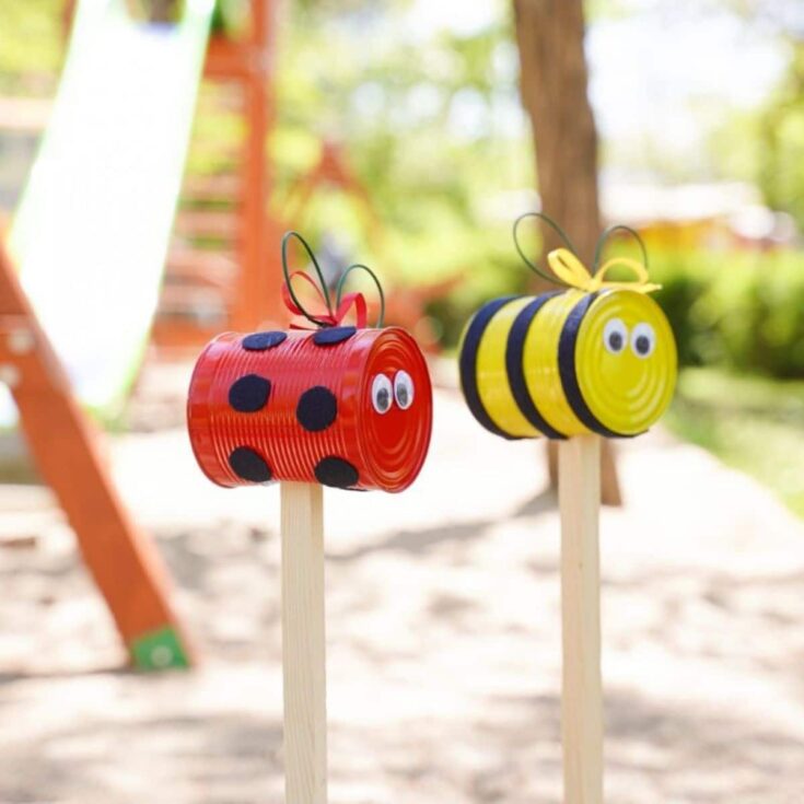 ladybug and bee garden stakes in front of swingset