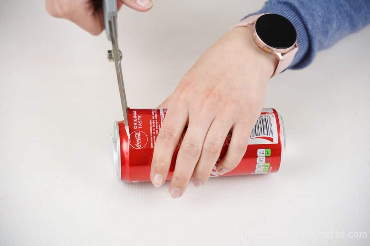 gray scissors cutting coca cola can