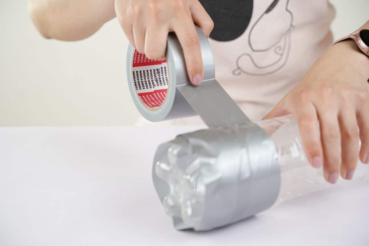 plastic bottle being wrapped in duct tape