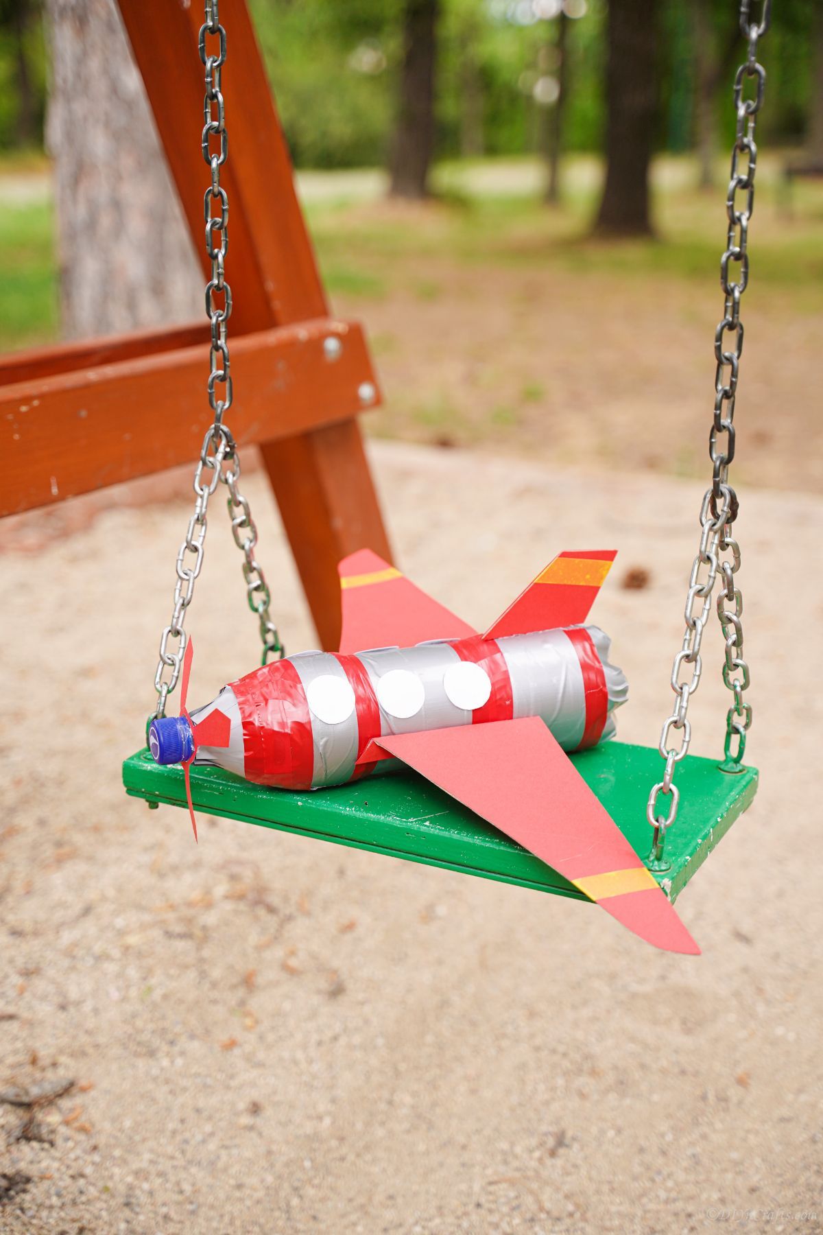 red and silver plastic bottle airplane on swignset