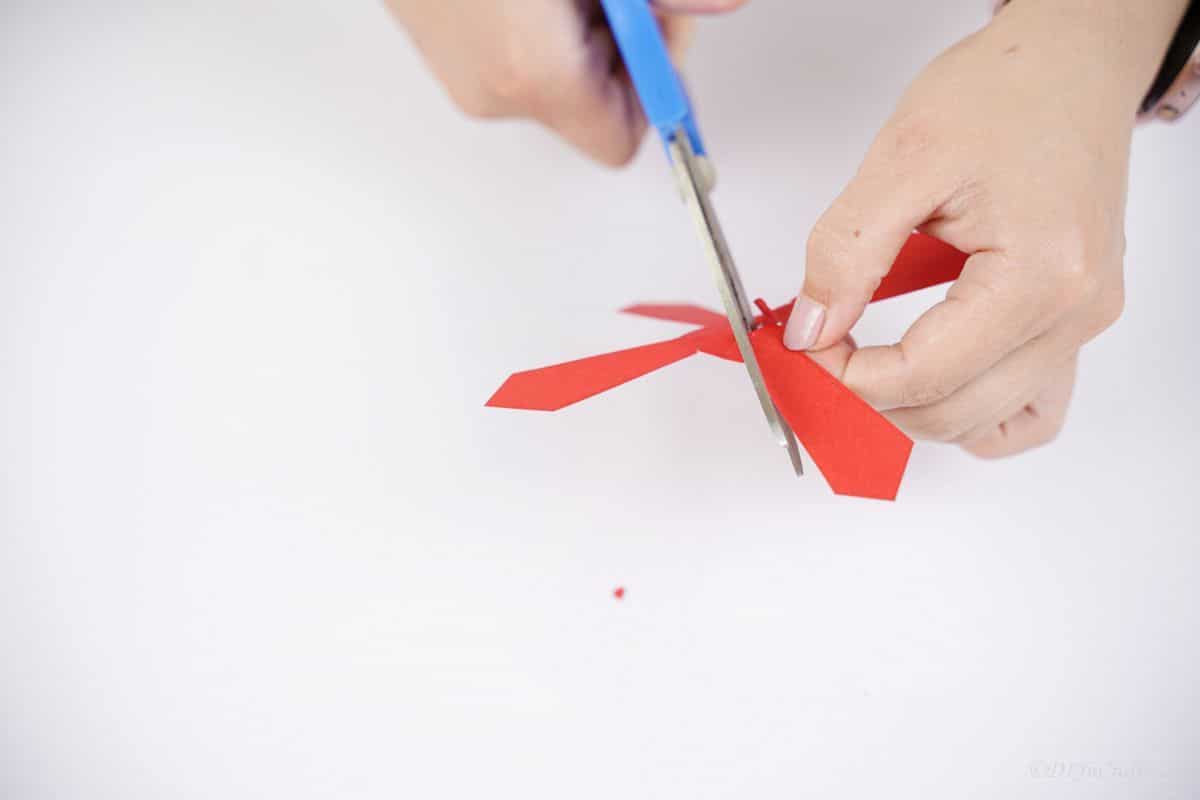 blue scissors cutting center of propeller paper