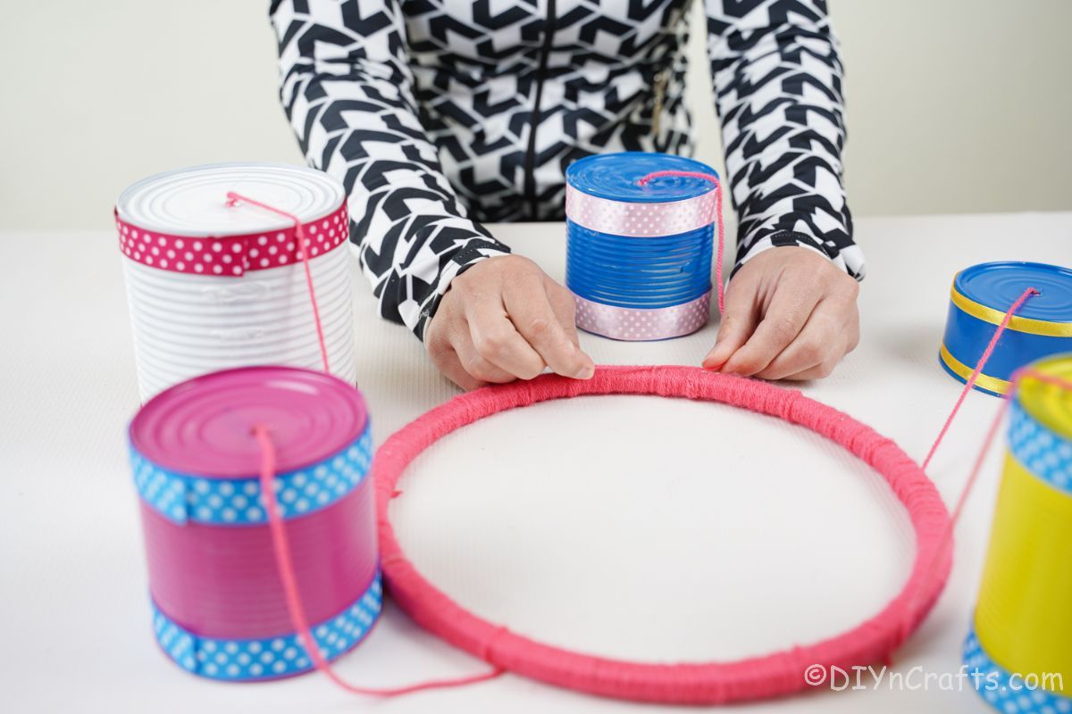 pink ring with tin cans tied to it on white table