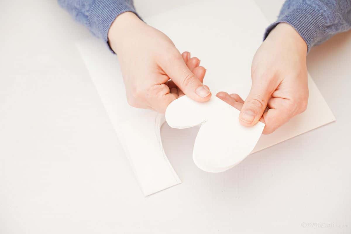 hand holding folded curved white piece of paper
