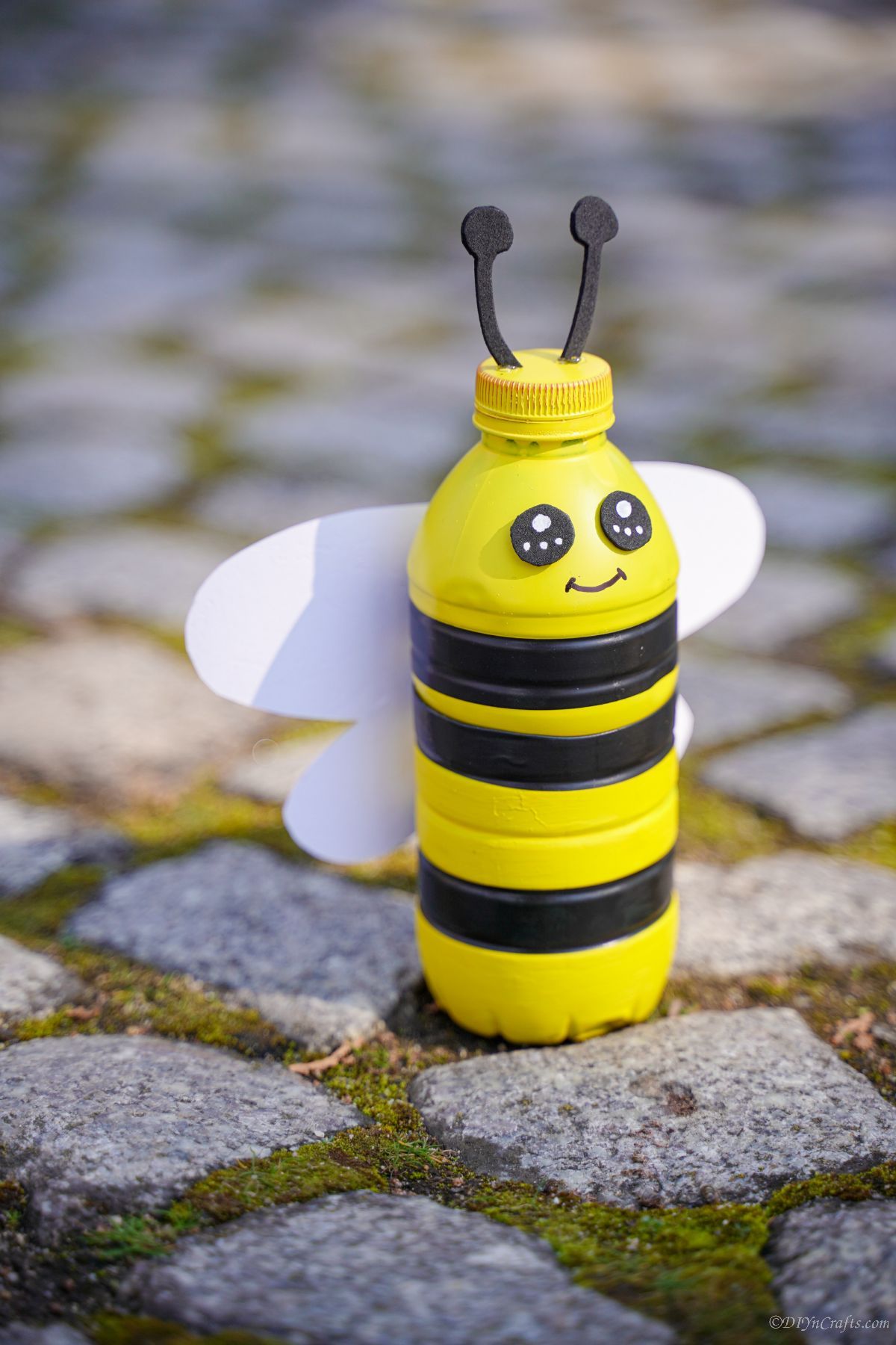 plastic bottle bumblebee on cobblestone