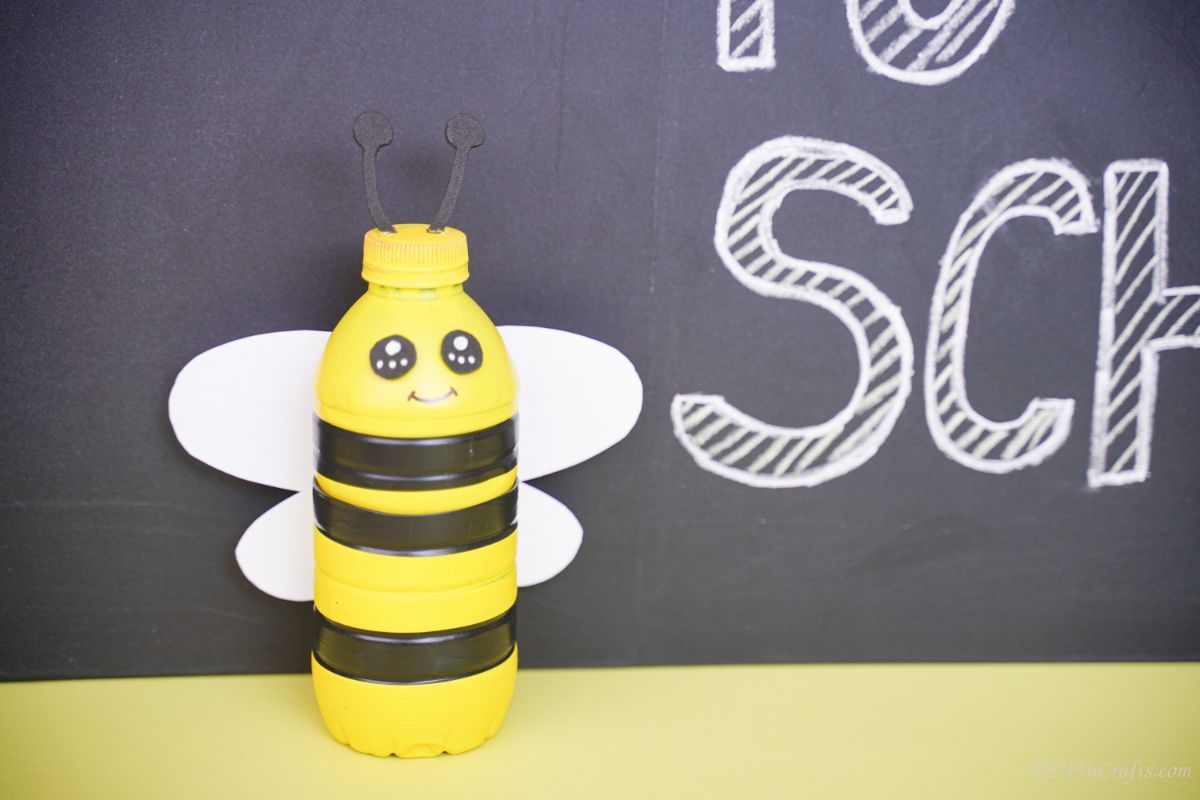 bee bottle on yellow table by chalkboard