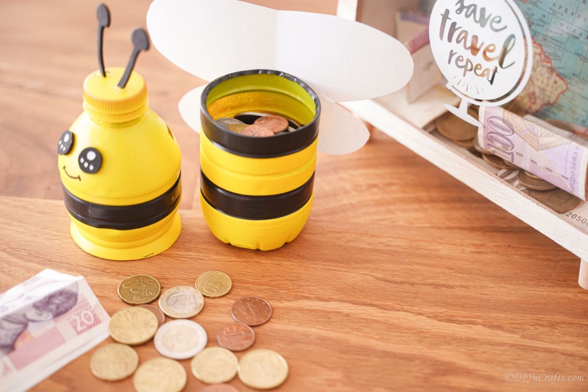 open bee piggy bank on table by loose change