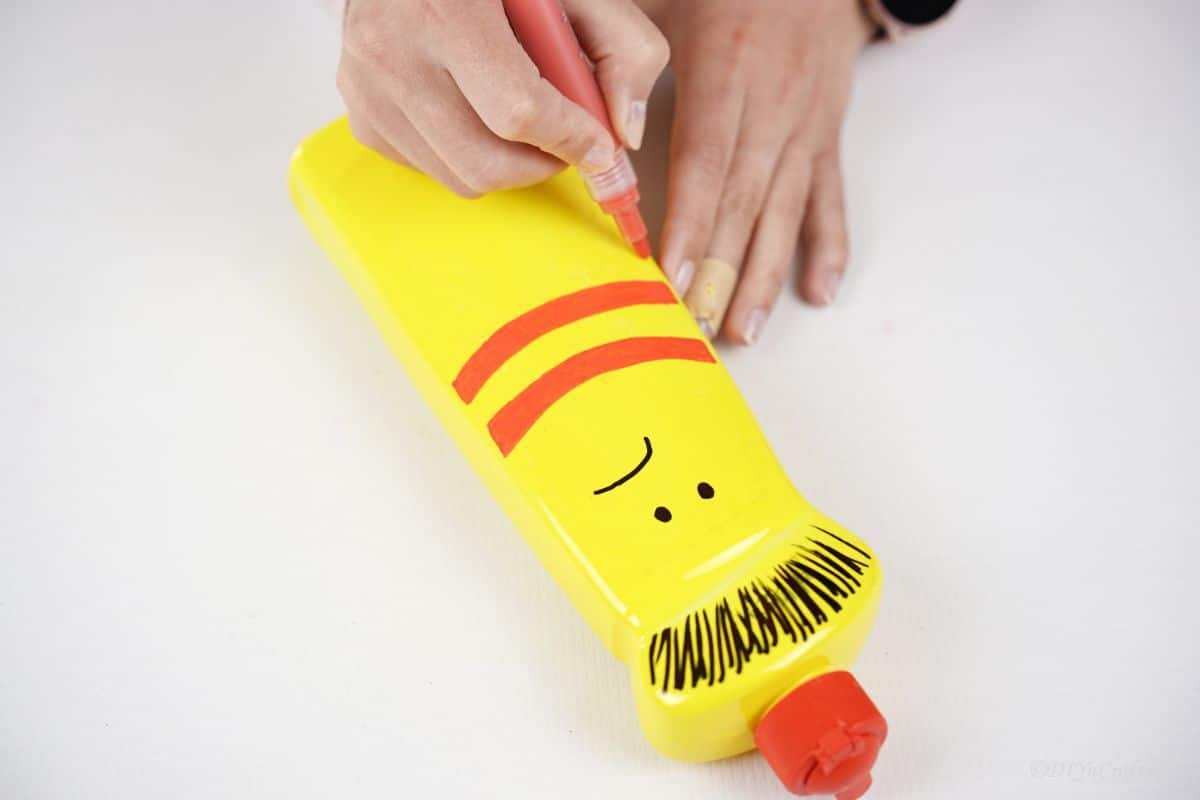 red stripes being drawn on yellow bottle