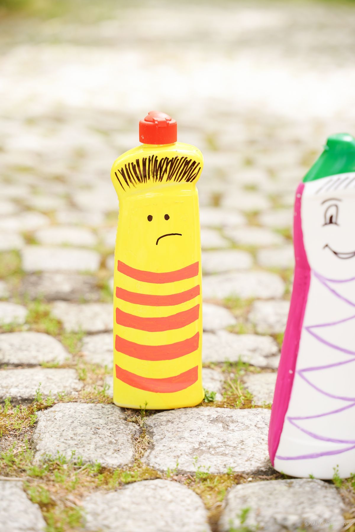 yellow and red character puppet bottle on stones