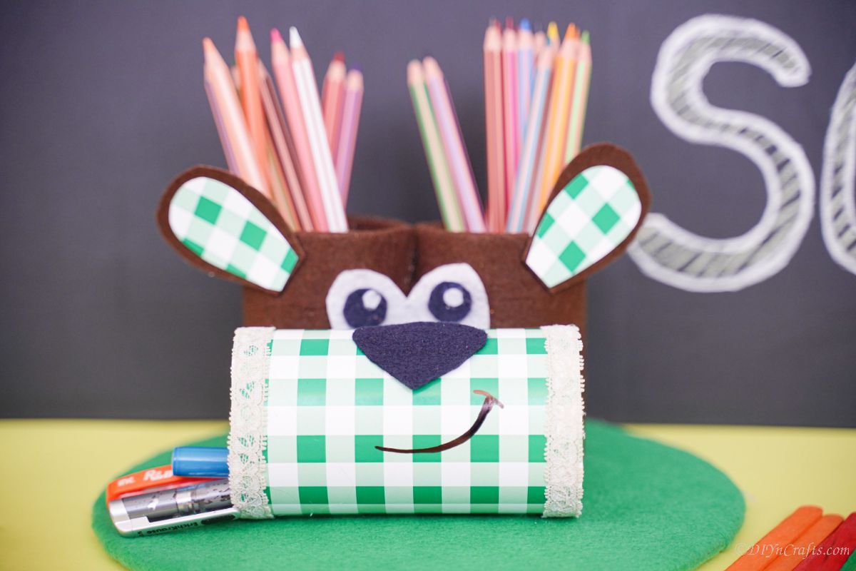 dog pencil holder on green base in front of chalkboard