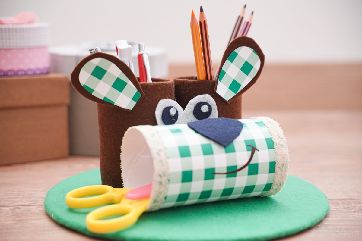 greena nd brown puppy pencil holder on green mat on table