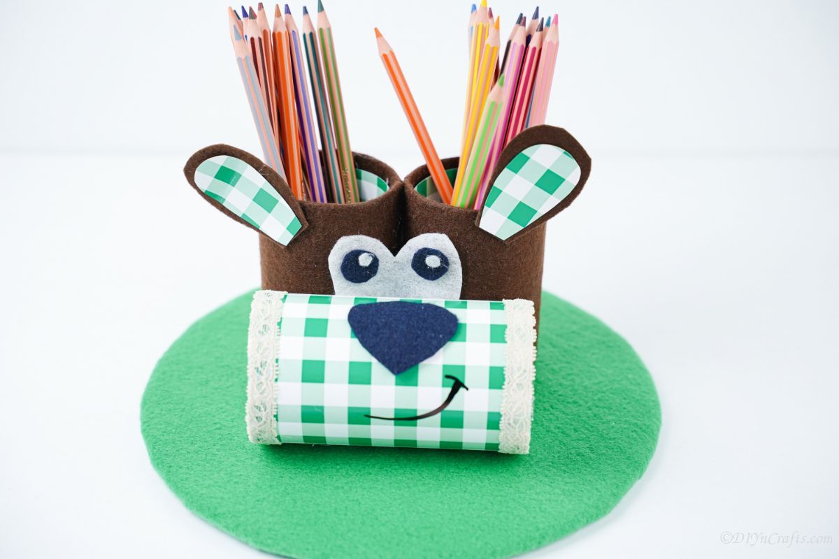white background behind green and brown dog pencil holder