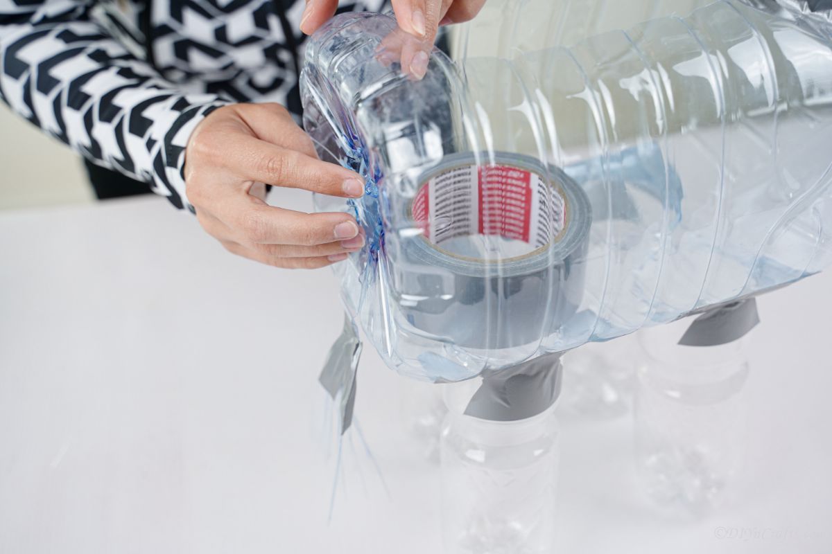 duct tape being wrapped around plastic bottles