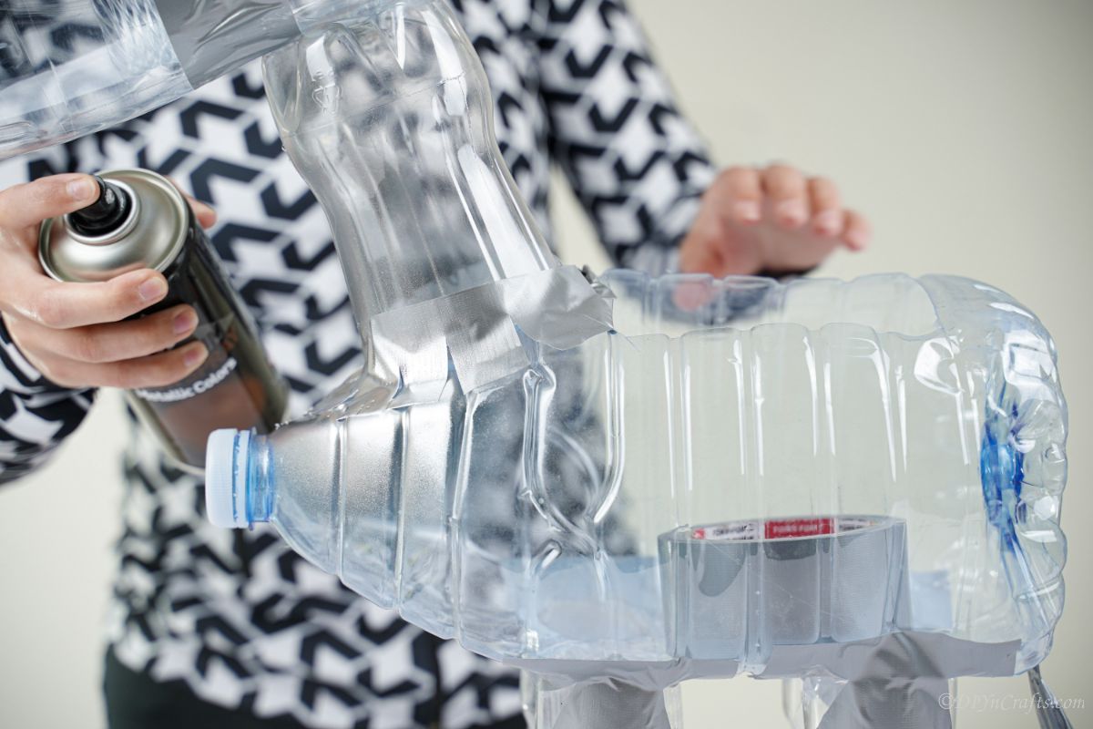 woman gluing plastic bottles together