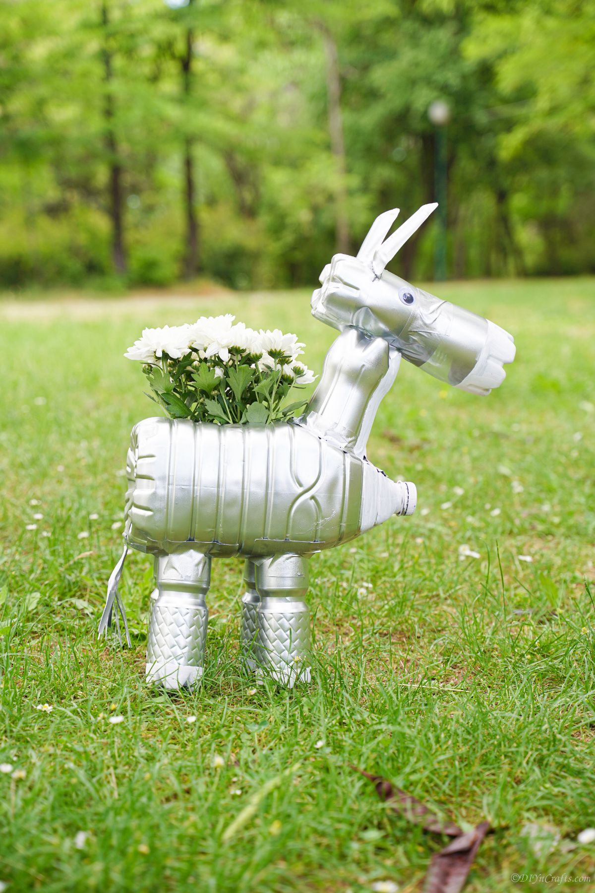 horse planter with white flowers outside in grass