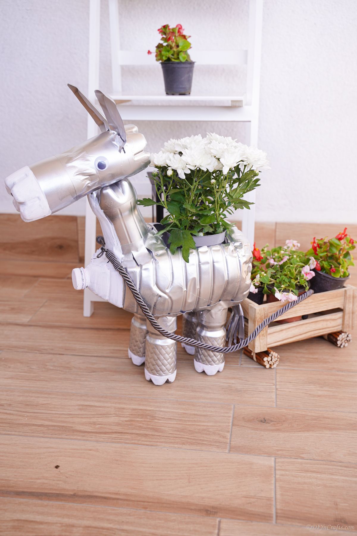 silver donkey planter on table in front of white shelf