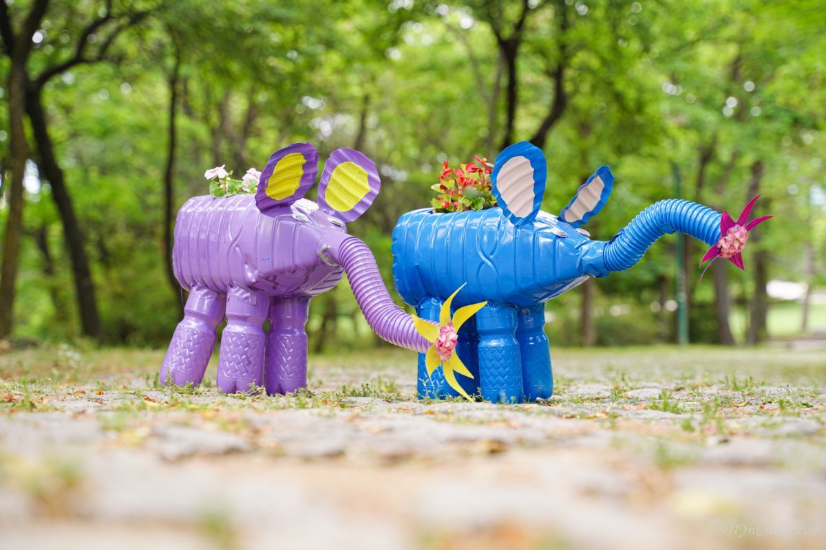 a purple and a blue elephant planter on stone path